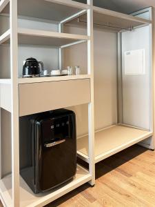 a kitchen with a coffee maker in a cupboard at Oca Bom Sucesso Hotel in Porto