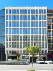 un grande edificio con macchine parcheggiate di fronte di Oca Bom Sucesso Hotel a Porto