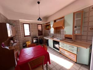 a kitchen with a table with a red table cloth at Lido Apartments in Sciacca