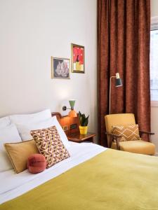 1 dormitorio con 1 cama y 1 silla en Max Brown Hotel Missori, part of Sircle Collection, en Milán