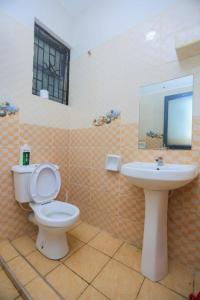 a bathroom with a toilet and a sink at Nziwa's Paradise Bamburi in Mombasa