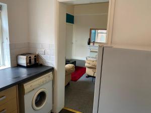 a kitchen with a washer and dryer in a room at Branxiar Castle - Stylish & Elegant 3 Bedroom Apartment in Wallsend, North Tyneside in Old Walker