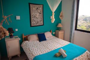 um quarto com uma cama e uma parede azul em Paradise Gardens em Xaghra