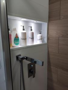 un bagno con quattro rotoli di carta igienica su una mensola di Villaverde Rooms, privada baño compartido a Madrid