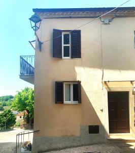 a building with two windows and a door at Casetta romantica a Collepardo in Collepardo