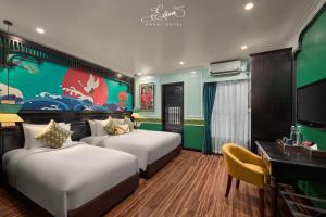 a hotel room with two beds and a desk at Eliana Signature Hanoi Hotel in Hanoi