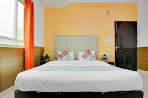 a bedroom with a large bed with an orange headboard at HOTEL THE LAZEEZ in New Delhi