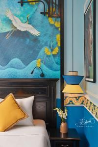 a bedroom with a bed and a painting of birds at Eliana Signature Hanoi Hotel in Hanoi