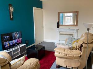 a living room with two chairs and a flat screen tv at Branxiar Castle - Stylish & Elegant 3 Bedroom Apartment in Wallsend, North Tyneside in Old Walker