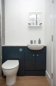 a bathroom with a white toilet and a sink at Cara Lodge, Comfortable Self Check-in En-suite Guest Rooms in Berwick-Upon-Tweed