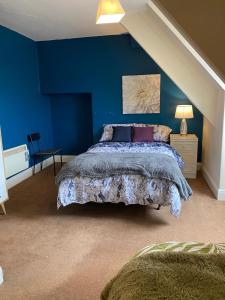 a bedroom with blue walls and a bed with a bedspread at Branxiar Castle - Stylish & Elegant 3 Bedroom Apartment in Wallsend, North Tyneside in Old Walker