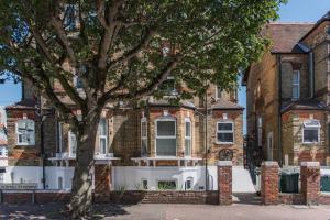 a large brick house with a tree in front of it at The Courtyard in Folkestone