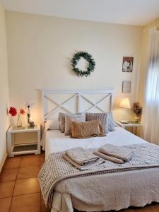um quarto com uma cama grande e uma coroa de flores na parede em Apartamento rural La Encina Complejo La Fontanina em Mata de Alcántara