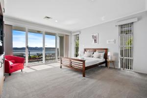 una camera con letto e sedia rossa di Super nice house with sea view free parking a Sandy Bay
