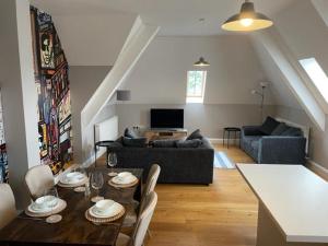 a living room with a table and a couch at Two Bedroom Duplex Apartment The Priory in St. Ives