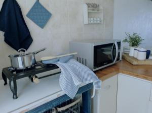 a kitchen counter with a microwave and a stove at Beachfront at 22 Settler's Sands in Port Alfred