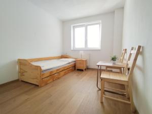 een slaapkamer met een bed, een tafel en een raam bij Turistická ubytovňa Hornád in Spišské Tomášovce