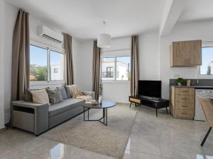 a living room with a couch and a tv at Sanders White Mountains Pool Villas in Paphos