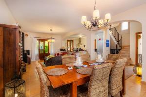 comedor y sala de estar con mesa de madera y sillas en Casa Stevens en Colonia de San Pedro