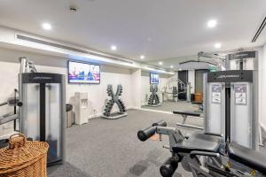 a gym with treadmills and machines in a room at Paradise Escape - Poolside Ground Floor - Sea Temple Resort and Spa in Port Douglas