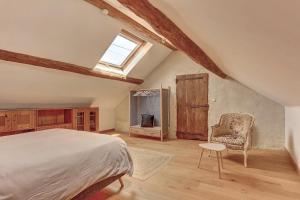ein Schlafzimmer mit einem Bett, einem Stuhl und einem Fenster in der Unterkunft Le Robinson - Classé 3 étoiles in Flins-sur-Seine