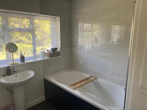 a bathroom with a bath tub and a sink at Double & Single Room Horley near Gatwick in Horley