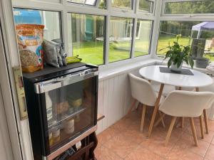 a kitchen with a table and a refrigerator and a table at Double & Single Room Horley near Gatwick in Horley