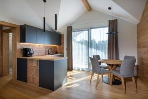 a kitchen and dining room with a table and chairs at Mountica Veľká Lomnica in Veľká Lomnica