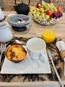 una mesa con un plato con un muffin y una taza de café en Chambre d hôtes LA MANDALA en Plan dʼAups