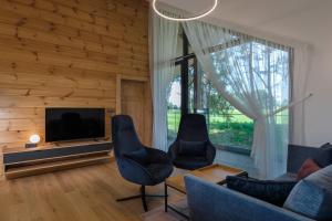 a living room with a couch and chairs and a television at Mountica Veľká Lomnica in Veľká Lomnica