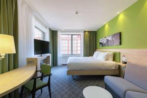 a hotel room with a bed and a desk at Hampton By Hilton Antwerp Central Station in Antwerp