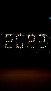 a lit up sign with lights in the dark at Bidiya Desert Camp in Aflāj