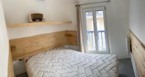 a small bedroom with a bed and a window at maison de village in Ax-les-Thermes