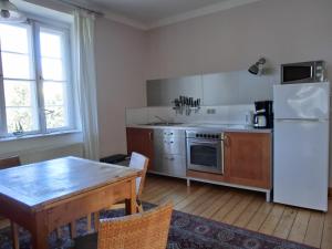 a kitchen with a table and a white refrigerator at Strandstraße 60 Ferienwohnung S14 in Graal-Müritz +6 photos