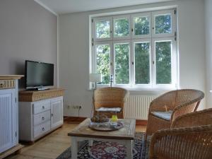 a living room with a tv and two chairs and a table at Strandstraße 60 Ferienwohnung S14 in Graal-Müritz