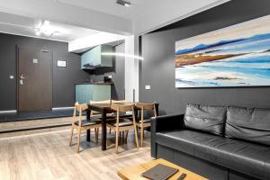 a living room with a black couch and a table at Stay Apartments Bolholt in Reykjavík