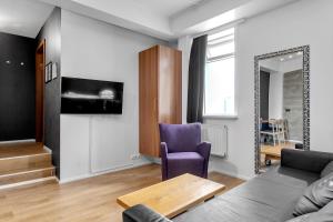 uma sala de estar com um sofá, uma mesa e um espelho em Stay Apartments Bolholt em Reykjavík