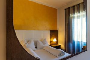 a bedroom with a bed with a mirror above it at Villa Ginevra Resort Agrituristico in Ficarra