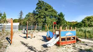 a playground with a slide and a swing set at Apartamenty Sun & Snow Półwysep Dziwnów in Dziwnów