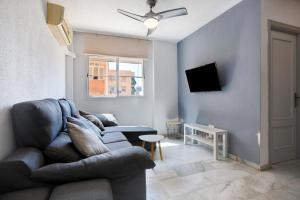 een woonkamer met een bank en een tv bij Heroes de sostoa 56 in Málaga