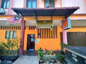 an orange building with a sign for a hotel at Rz Gold Hotel Official Account in Kuala Kerai