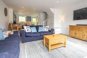 uma sala de estar com um sofá azul e uma mesa em Spring Lake 52, Eider Lodge - P em South Cerney