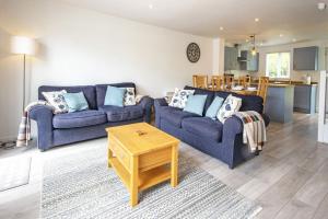 uma sala de estar com dois sofás azuis e uma mesa em Spring Lake 52, Eider Lodge - P em South Cerney