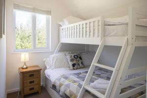 um beliche branco num quarto com uma janela em Spring Lake 52, Eider Lodge - P em South Cerney