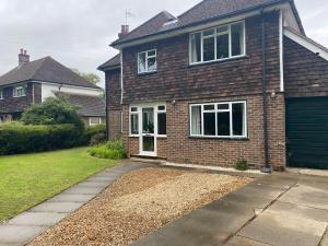 a brick house with a garage and a driveway at Double & Single Room Horley near Gatwick in Horley