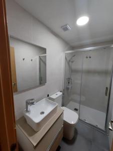 ein Bad mit einem Waschbecken, einer Dusche und einem WC in der Unterkunft Apartamento en playa de Valdelagrana in El Puerto de Santa María