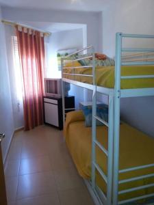 1 Schlafzimmer mit 2 Etagenbetten in einem Zimmer in der Unterkunft Apartamento en playa de Valdelagrana in El Puerto de Santa María