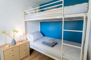 a bedroom with two bunk beds and a night stand at Cwter Hywel in Coedana