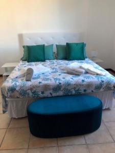 a bed with a blue comforter and green pillows at Attici Agli Acquedotti Romani in Rome