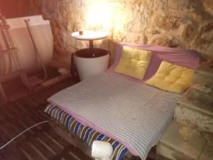 a bedroom with a bed with purple and yellow pillows at MiniCasa con vistas a las Hoces del río Riaza. in Montejo de la Vega de la Serrezuela